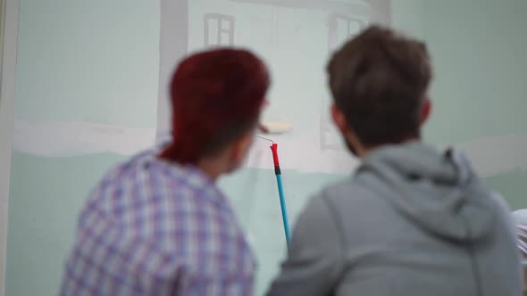 Wall with House Drawing and Blurred Couple Hugging Talking at Front