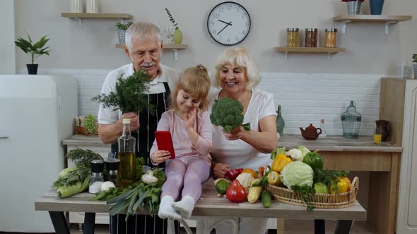 Blogger Girl Making Selfie on Phone with Senior Couple Grandparents at Kitchen with Vegetables