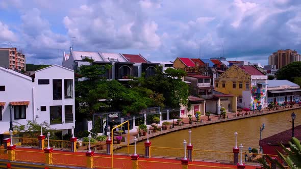 Aerial flight above melaka river with colorful bridge and house buildings,Asia