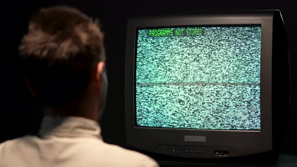 Over the Shoulder of a Man Holding a Retro TV Remote Control and Changing Media Channels