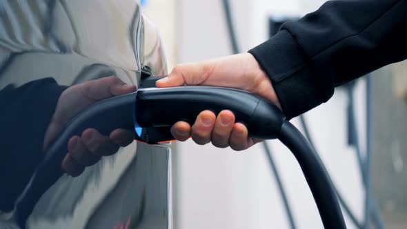 Refueling Nozzle Is Getting Pulled Out From a Filler Hole of an Electric Vehicle