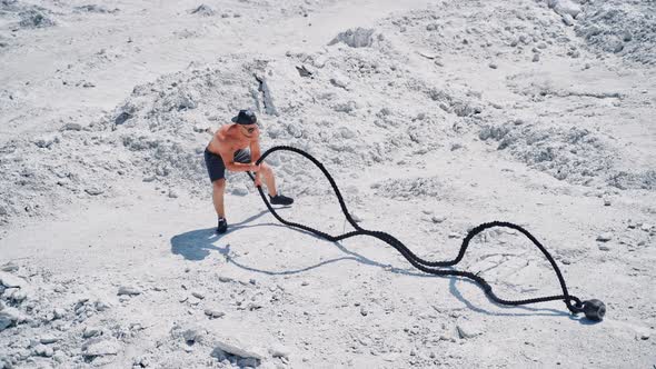 Aerial shot of a man working out with battle ropes.