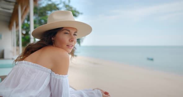 Young Woman in Hat Enjoys Her Travel She Lift on the Railings at the Cafe and Enjoys the Sea View