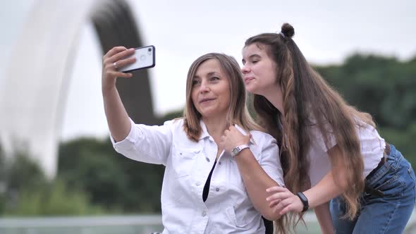 Happy Girl and Disabled Mom Taking Selfie Outdoors