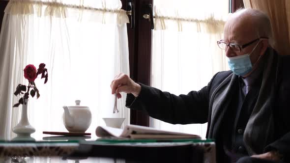 Grayhaired Grandfather with Glasses is Resting and Reading a Fresh Newspaper