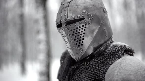 Portrait Closeup of Militant Medieval Knight Wearing Traditional Steel Armor and Helmet Sword