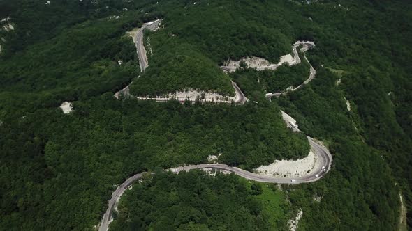 Aerial View From Above of Curve Road with a Car on the Mountain with Green Forest in Russia