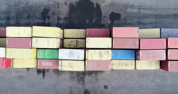 Top down view of colorful containers piles and truck in port container terminal,