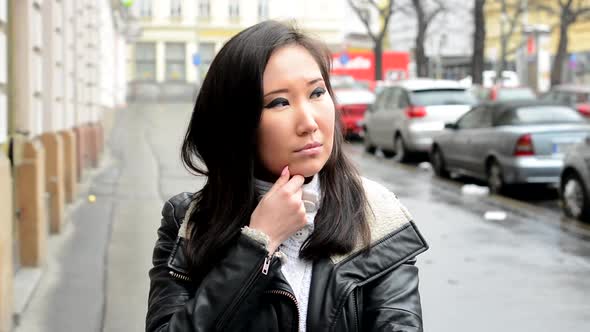 Young Attractive Asian Woman Thinks - Urban Street with Cars - City
