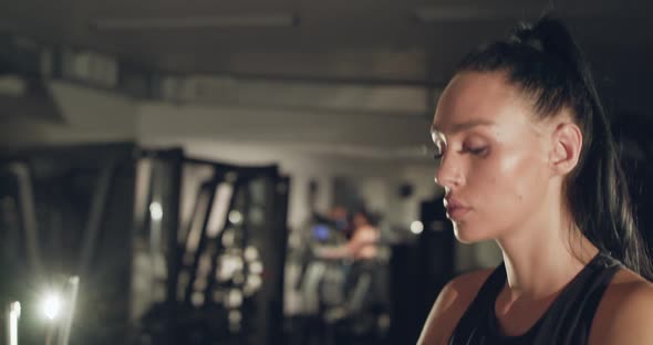 Concentrated Female Athlete During Stepping on a Treadmill in a Gym