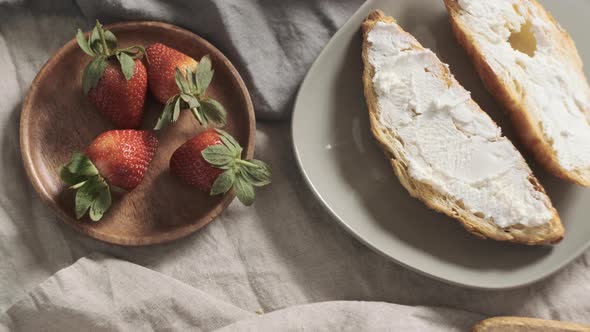 Girl or Woman Take One Strawberry with Her Hand and Ready to Decorate Croissants Wich Lay Near with