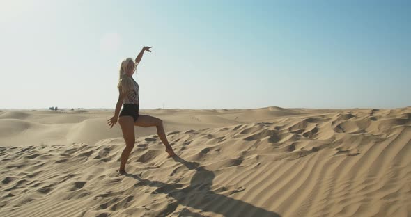 Pretty Lady with Blonde Hair is Dancing in the Middle of the Desert UAE