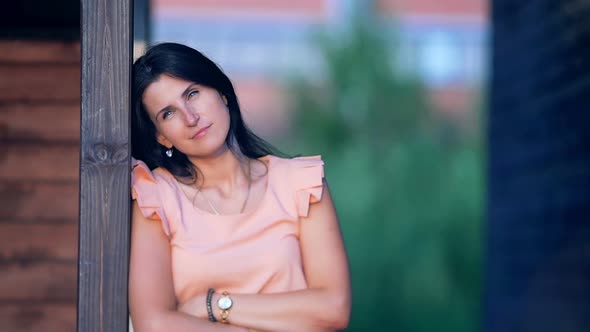 Portrait of a Sad Young Women Who Relies on the Wooden Wall