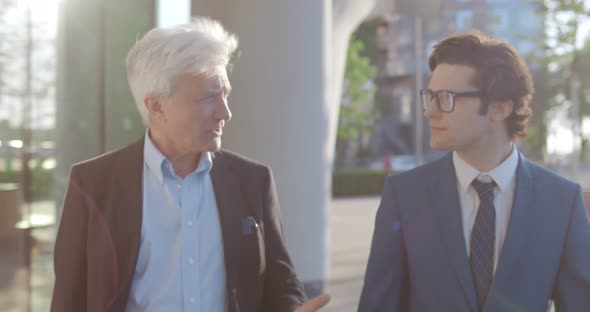 Medium Shot of Happy Business Colleagues Having Conversation Walking Outside