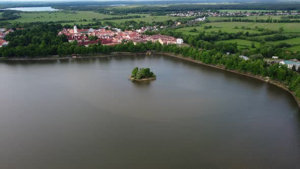 Aerial footage of a small historic town Trebon surrounded by a big pond with islet. Czech Republic.