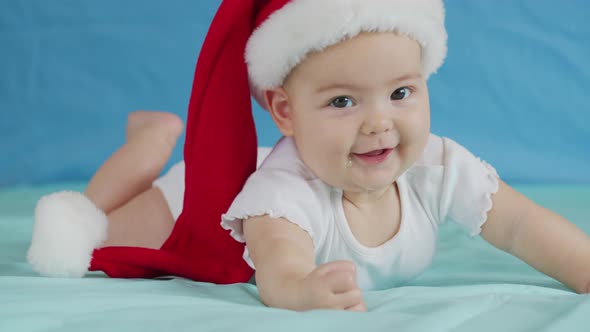 Portrait of Adorable Infant Baby Girl Wearing Santa Hat. Christmas Celebration Concept.