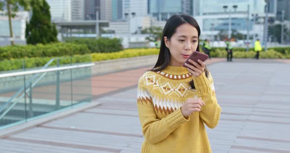 Asian Woman Use of Mobile Phone in City 