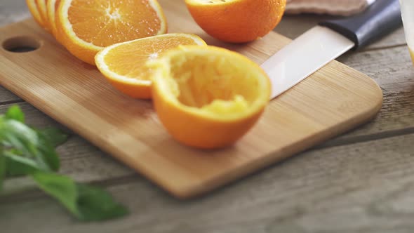Freshly Squeezed Orange Juice On Textured Wooden Table. Orange Slices, Halves Of Squeezed Oranges