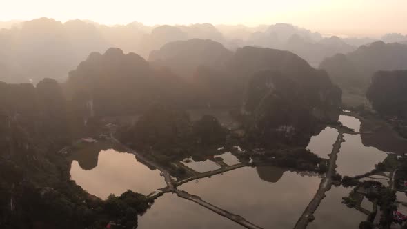 Aerial: North Vietnam karst landscape at sunset, drone view of Ninh Binh region, tourist destination