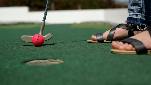 Girl playing miniature golf in the garden 4k