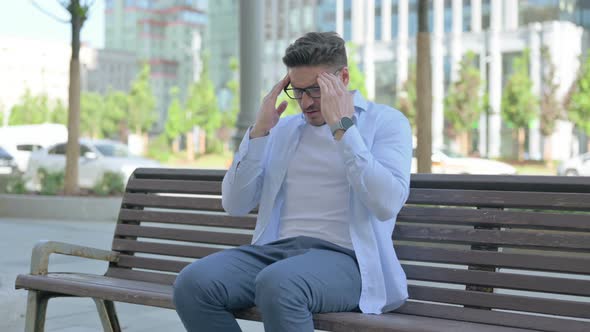 Man with Headache Sitting Outdoor on Bench