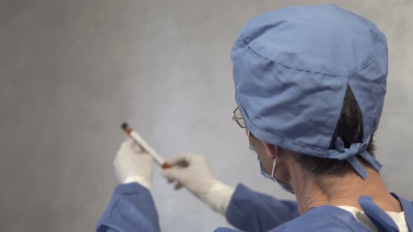 A doctor holds a test tube with a covid-19 test vaccine in his hand.