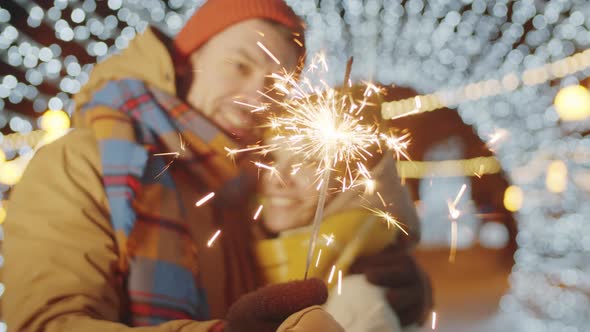 Couple Holding Christmas Sparkler and Kissing