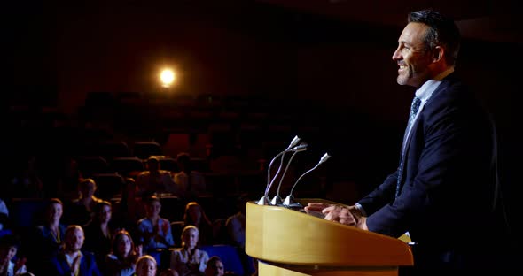 Caucasian businessman speaking in business seminar on stage in auditorium 4k