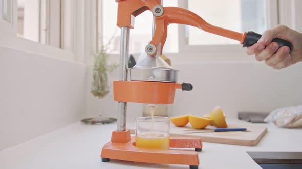 Super slow motion of fresh orange juice squeezed using a manual squeezer