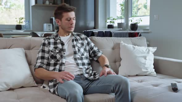 Man Sitting on Sofa and Watch TV