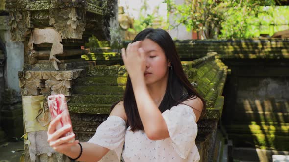 Teenage Chinese tourist explores a temple in Bali.