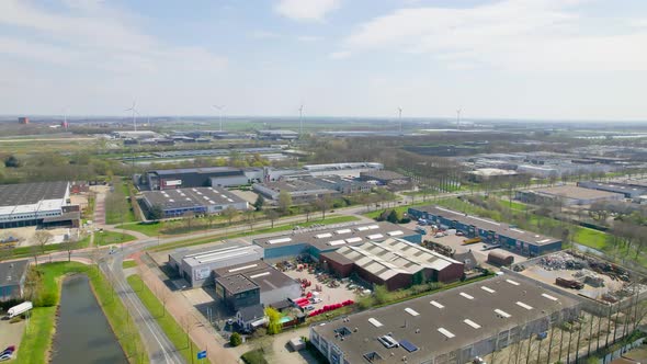 Aerial view over industrial park, wind turbines in background