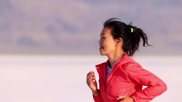 Asian woman jogging across the Bonneville Salt Flats flats