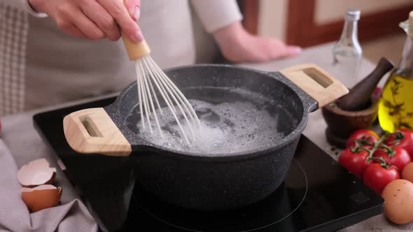 Poached Eggs Cooking  Woman Whipping Boiling Water with Salt and Vinegar in a Pot