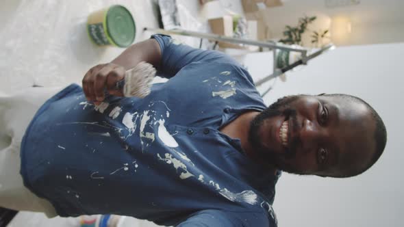 Black Man Talking on Web Call while Painting Room