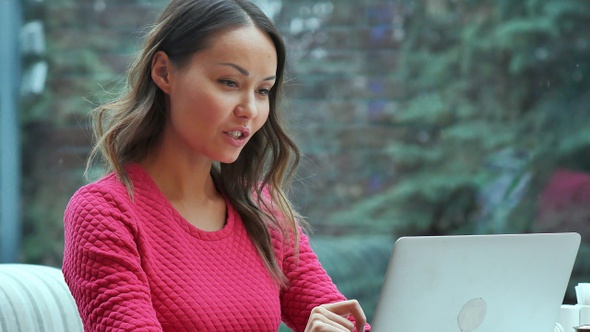 Happy Blond Woman Using Laptop Having Video Conference in Cafe