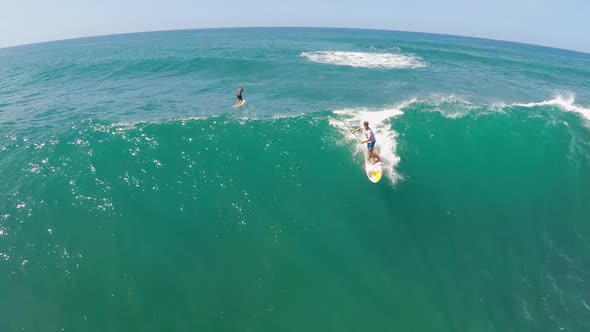 Aerial view of a man sup stand-up paddleboard surfing in Hawaii