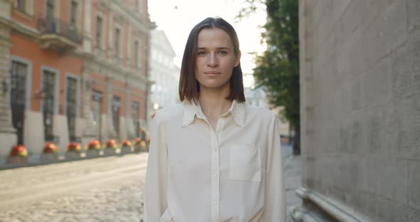 Portrait of Millennial Pretty Woman Turning Head and Looking To Camera. Charming Girl in White Shirt