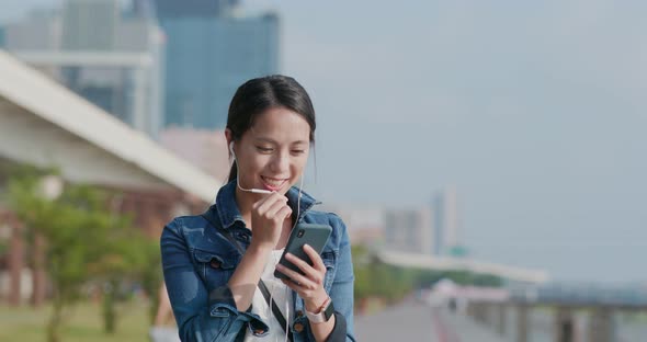 Woman talk to earphone on cellphone in the city