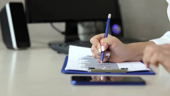 Business analytics. Girl makes notes on charts