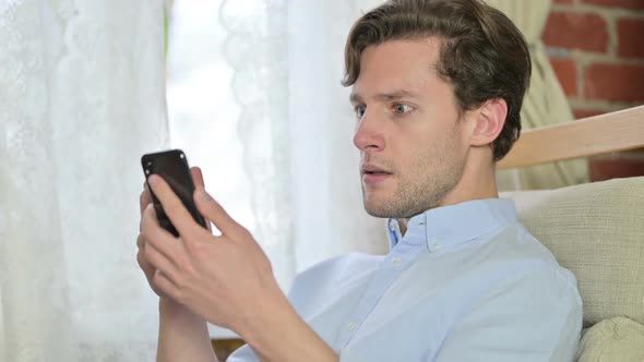 Portrait of Young Man Get Disappointed on Smartphone