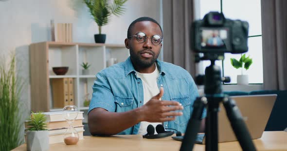 African American Blogger in Glasses Recording Video on Camera for His Internet Audience