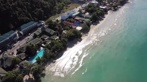 Flying a drone over the first coastline of the Chang island beach. View of hotels, pools