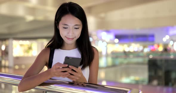 Woman using smart phone in shopping mall