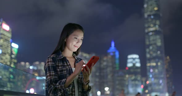 Woman check on mobile phone at outdoor in city at night