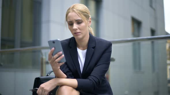 Businesswoman Upset With Message in Smartphone, Troubles at Work, Depression