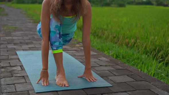 Slowmotion Shot of a Young Woman Practicing Yoga on a Beautiful Rice Field