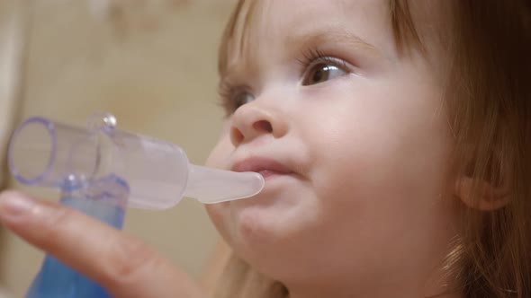 Child Is Sick and Breathes Through an Inhaler. Toddler Treats Flu By Inhaling Inhalation Vapor