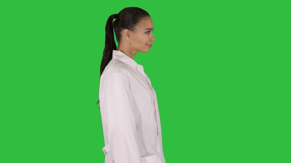 Doctor beautician in a white robe is walking on a Green