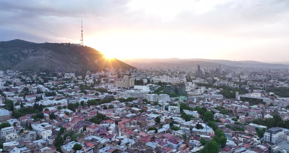 Aerial view of center of Tbilisi under Mtatsminda mountain at sunset. Georgia 2022 summer